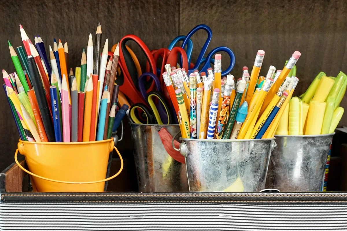 Colorful school supplies in buckets.